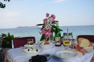 a table with food and a bottle of wine and flowers at Hotel Villa Nisteri in Limenas