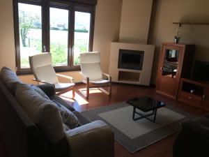 sala de estar con sofá y 2 sillas en Chalet La Caleya en Otur