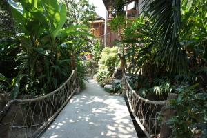 a rope bridge in the middle of a garden with trees at Tropical Garden Bungalow in Phi Phi Don