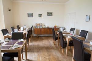 une salle à manger avec des tables et des chaises en bois dans l'établissement Llwyn Onn Guest House, à Merthyr Tydfil