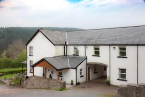 a white house with a gray roof at Llwyn Onn Guest House in Merthyr Tydfil