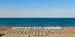 a large group of umbrellas and chairs on a beach at Margheritamare in Margherita di Savoia