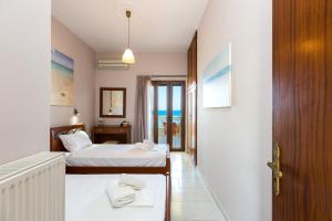 a hotel room with two beds and a balcony at Glaros in Panormos Rethymno