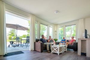 um grupo de pessoas sentadas num sofá numa sala de estar em Tussen de Diepen em Blokzijl