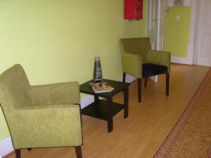 a room with two chairs and a table with a vase on it at Residencial S Juliao AL in Figueira da Foz