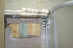een groep handdoeken hangend aan een rek in een badkamer bij Apartment Gashi in Pristina +20 foto's