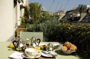 un tavolo con teiere e tazze e un piatto di cibo di Cote Montmartre a Parigi