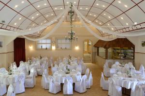 un salón de banquetes con mesas y sillas blancas en Gasthaus Johanning eK, en Uslar