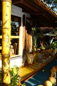 a porch with potted plants and a window at Pousada Bambu Brasil in Sao Jorge