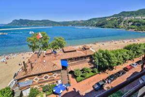 a view of a beach with a building and the ocean at Ay Işığı Pansiyon in Amasra