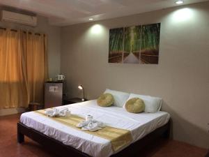 - une chambre avec un lit et des serviettes dans l'établissement Mañana Hotel, à Olongapo