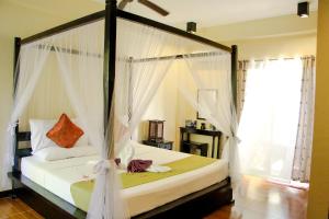 um quarto com uma cama de dossel e cortinas brancas em Sulu Sea Boutique Hotel em Boracay