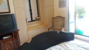 - une chambre avec un lit, une télévision et une chaise dans l'établissement Nel cuore del Centro, à Salerne