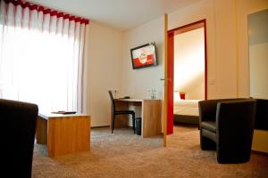 a room with a table and chairs and a mirror at Hotel Brauhaus Stephanus in Coesfeld