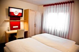 a bedroom with a bed and a desk and a television at Hotel Brauhaus Stephanus in Coesfeld