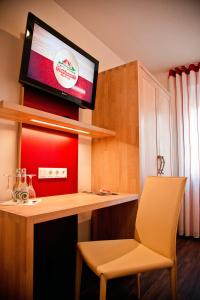 a room with a desk with a tv and a chair at Hotel Brauhaus Stephanus in Coesfeld