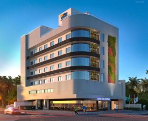 a large building with people walking in front of it at Blue Hill Hotel in Timbó