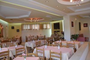 a banquet hall with tables and chairs with pink tablecloths at Hotel Villa Nisteri in Limenas