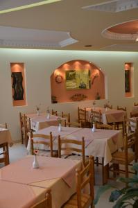 a restaurant with white tables and chairs and a mirror at Hotel Villa Nisteri in Limenas