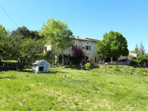 a house in a field with a fence at Gîtes La ferme accrochée à la colline in Lagorce