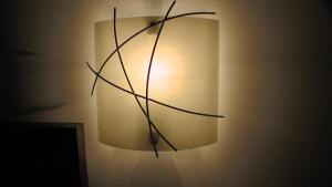 a light on a wall with a branch on it at Bay Lodge in Birchington
