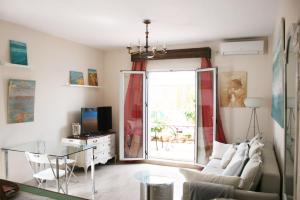 ein Wohnzimmer mit einem Sofa und einem Glastisch in der Unterkunft La Terraza Azul in Sevilla