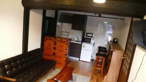 uma sala de estar com um sofá e uma cozinha em La cura em Takayama