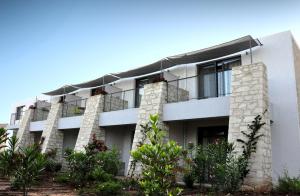 a white building with plants in front of it at Leivatho Hotel in Svoronata