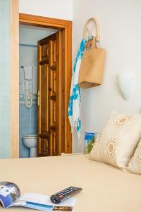 a remote control sitting on top of a bed at Appartamenti Baia di Citara in Forio d'Ischia +63 photos