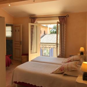 1 dormitorio con cama y ventana grande en Le Mazet des Mûres en Grimaud