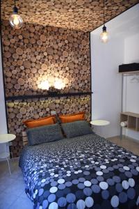 a bedroom with a bed and a wall of logs at la casa di asmei b & b Lucera in Lucera