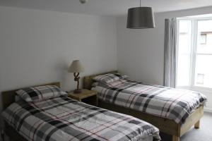 2 camas individuais num quarto com uma janela em The Pier Hotel em Aberystwyth