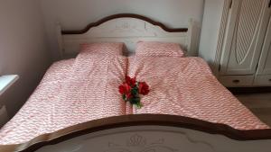 Una cama con una flor roja encima. en Zorza Polarna en Olsztyn