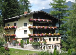 ein Gebäude mit Blumen auf den Balkonen in der Unterkunft Landhaus Gletschermühle in Bad Gastein