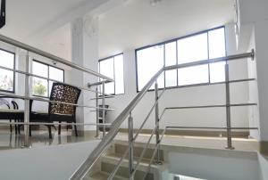 a staircase in a building with a chair and windows at Hotel Las Margaritas Alojamientos in Barranquilla