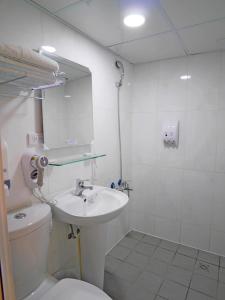 uma casa de banho com um lavatório, um WC e um espelho. em Good Night Hotel em Yangmei