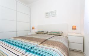 um quarto branco com uma cama e duas mesas de cabeceira em Apartman Iva em Šilo