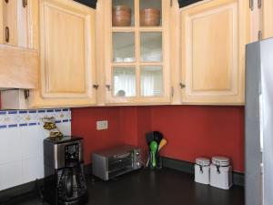 Una cocina con gabinetes de madera y microondas. en Cumbres de San Francisco, en San Salvador 11 fotos más