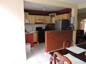 a kitchen with wooden cabinets and a table and chairs at Cumbres de San Francisco in San Salvador