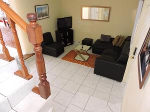 Una sala de estar con un sofá y un televisor. en Cumbres de San Francisco, en San Salvador
