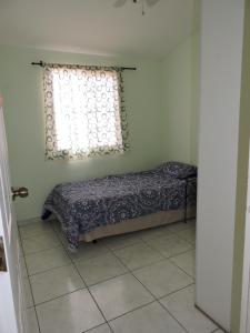Schlafzimmer mit einem Bett und einem Fenster in der Unterkunft Cumbres de San Francisco in San Salvador
