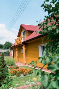 a yellow house with flowers in front of it at Zamsówka in Guciów