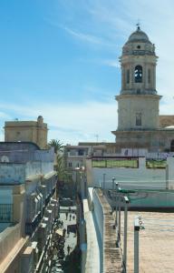 un edificio con una torre de reloj en una ciudad en Hotel Patagonia Sur, en Cádiz