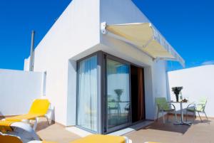 taras z krzesłami, stołem i oknem w obiekcie Hotel Apartamentos Patagonia Sur w Kadyksie