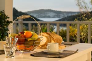 a basket of fruit and bread on a table on a balcony at Lioniskari in Porto Ozias