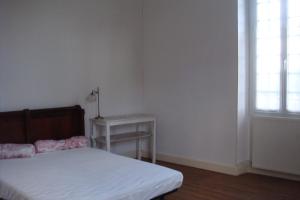 1 dormitorio con cama, mesa y ventana en Le Petit Carpia, en Castillon-de-Castets
