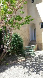 un edificio con mesa y sillas junto a un árbol en Le Petit Carpia, en Castillon-de-Castets