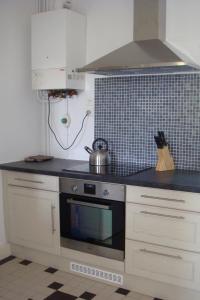 cocina con armarios blancos y fogones en Le Petit Carpia, en Castillon-de-Castets