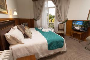 a bedroom with a large bed and a television at Hotel Plaza in Punta Arenas