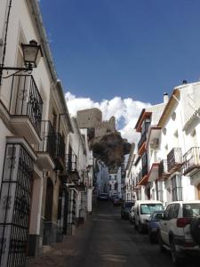 a city street with buildings and a castle in the background at No 31 Bed & Breakfast in Olvera